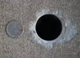 The hole needed for mudjacking compared to the size of a quarter 
